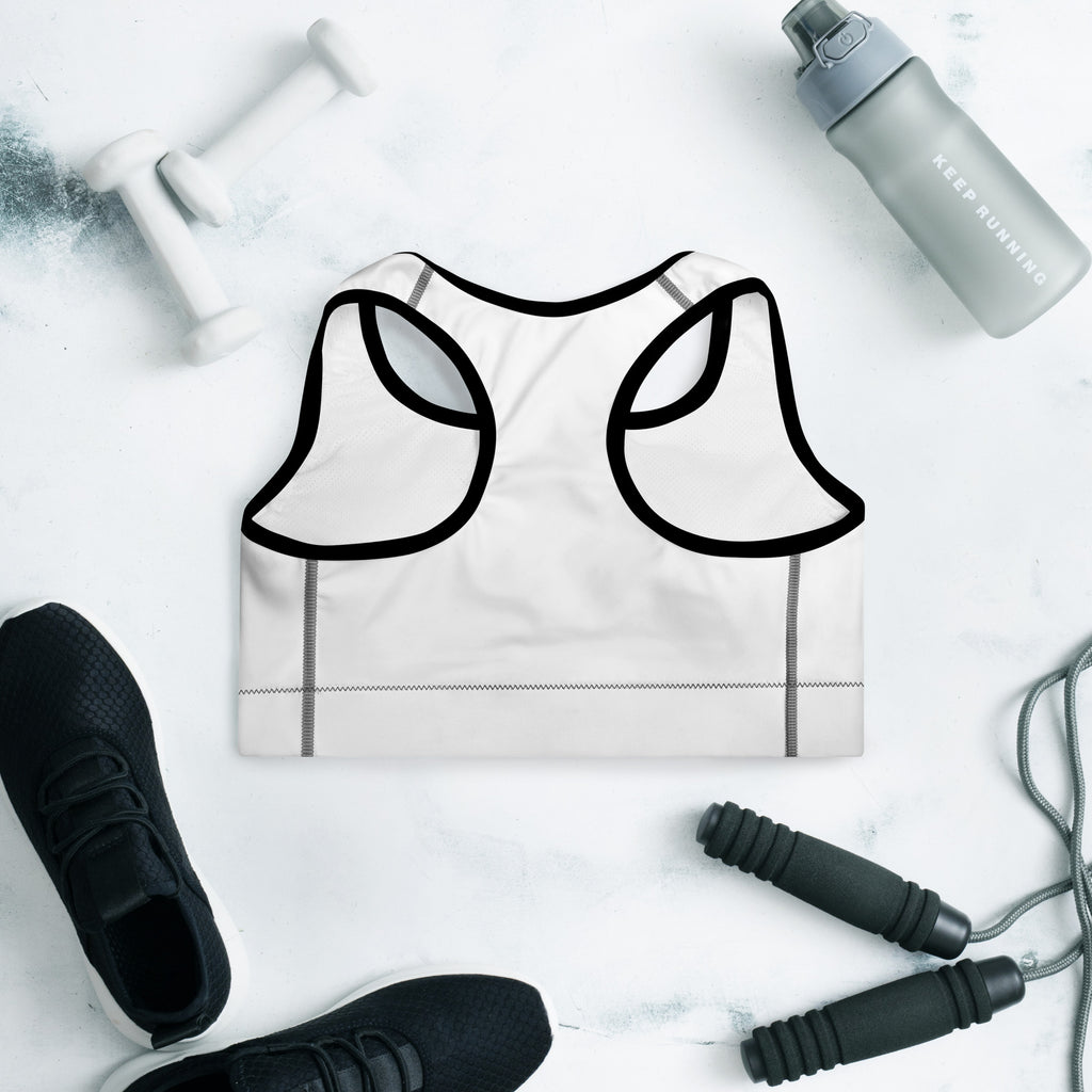 White sports bra with black lines, black sneakers, gray water bottle, and jump rope on a light wooden surface.