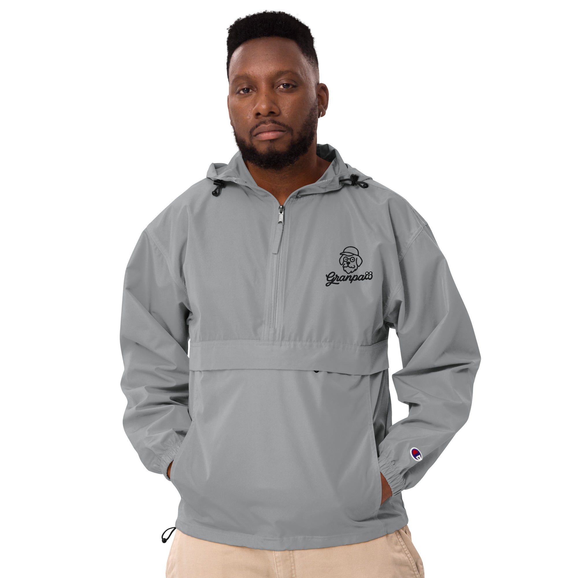 Man wearing a gray pullover with a logo on a white background