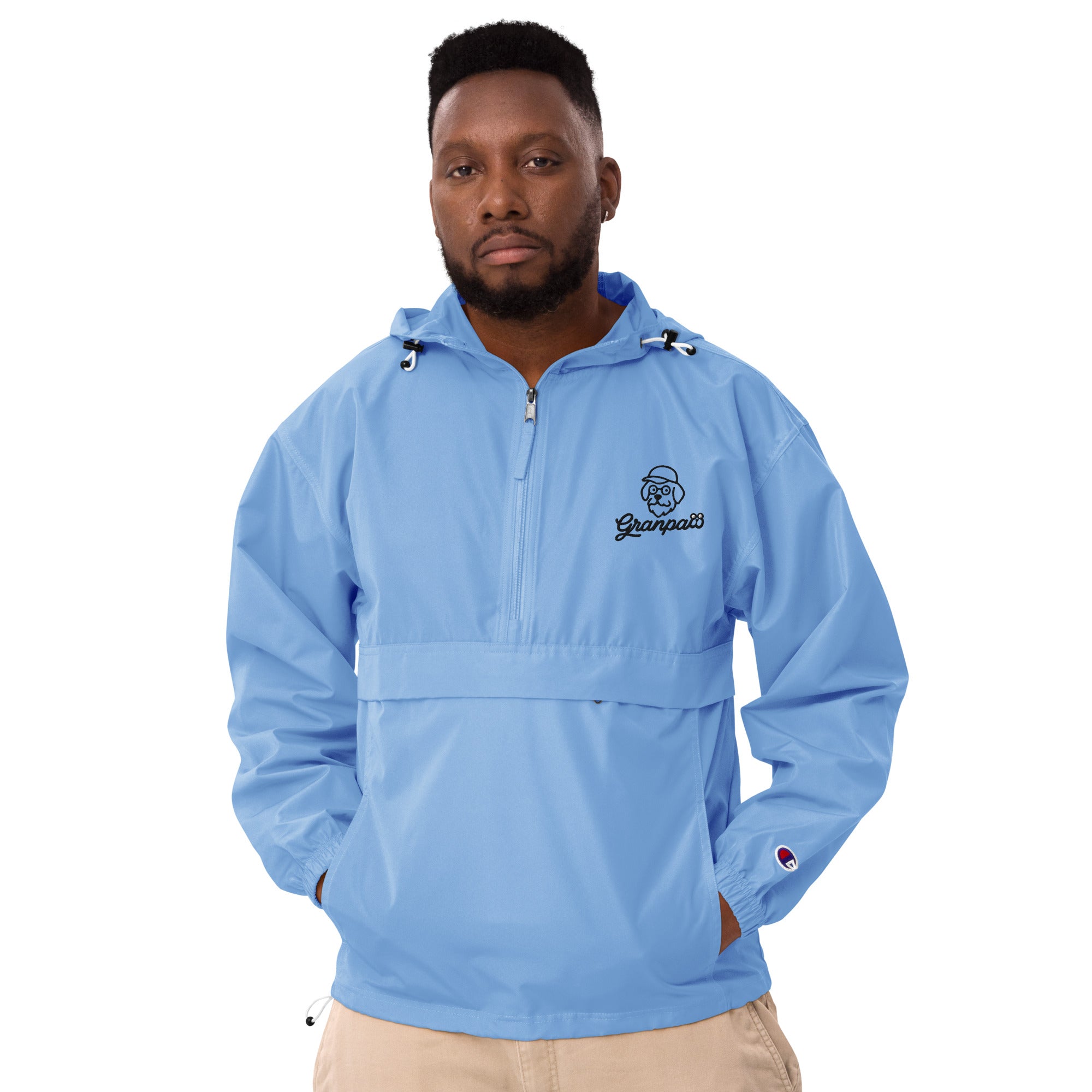 Man wearing a light blue pullover with a logo on a white background