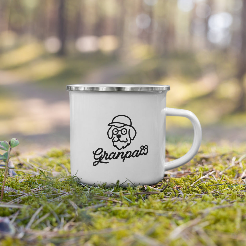 White mug with 'Granpaw's' logo on grass in a forest