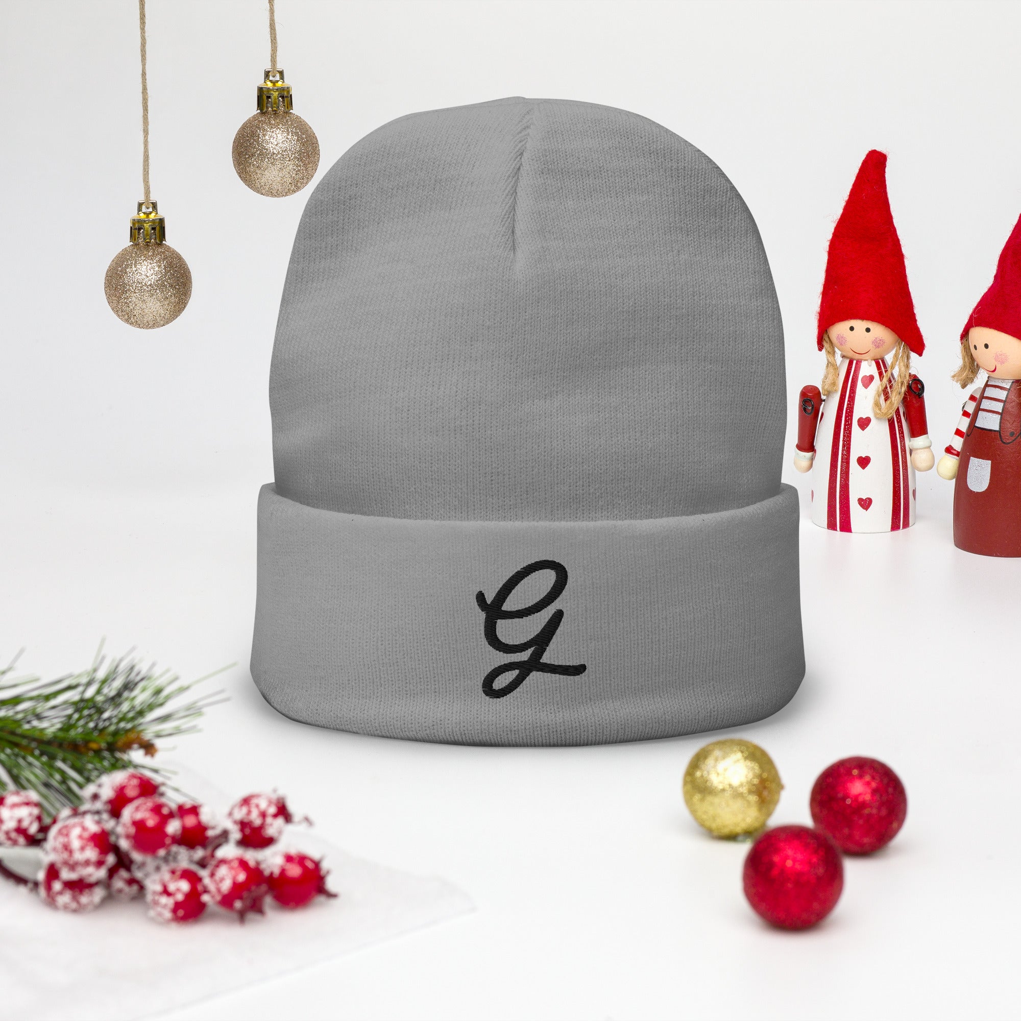 Gray beanie with a black letter 'G' on a white background with Christmas decorations.