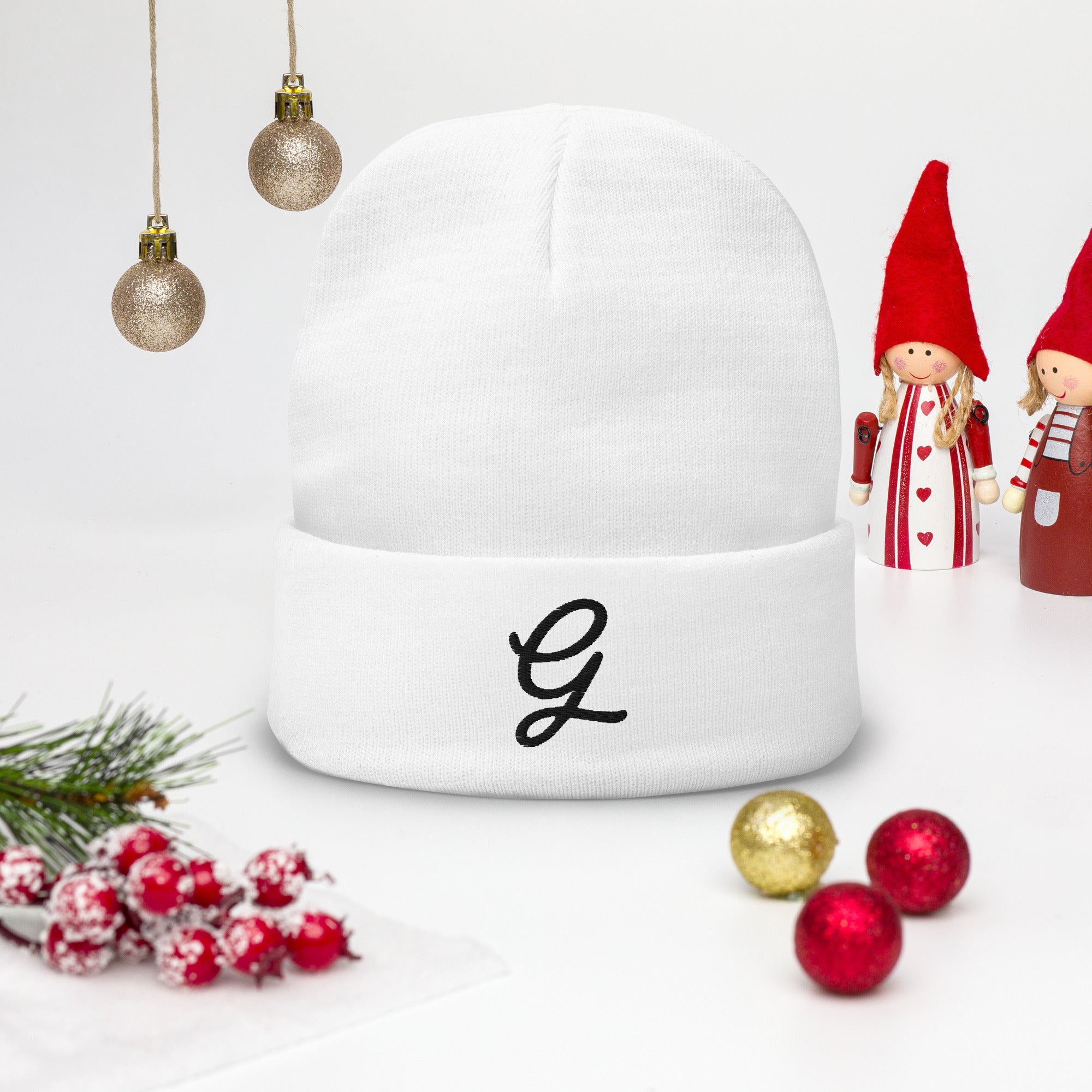 White snow globe with a letter 'G' on a white background with Christmas decorations.