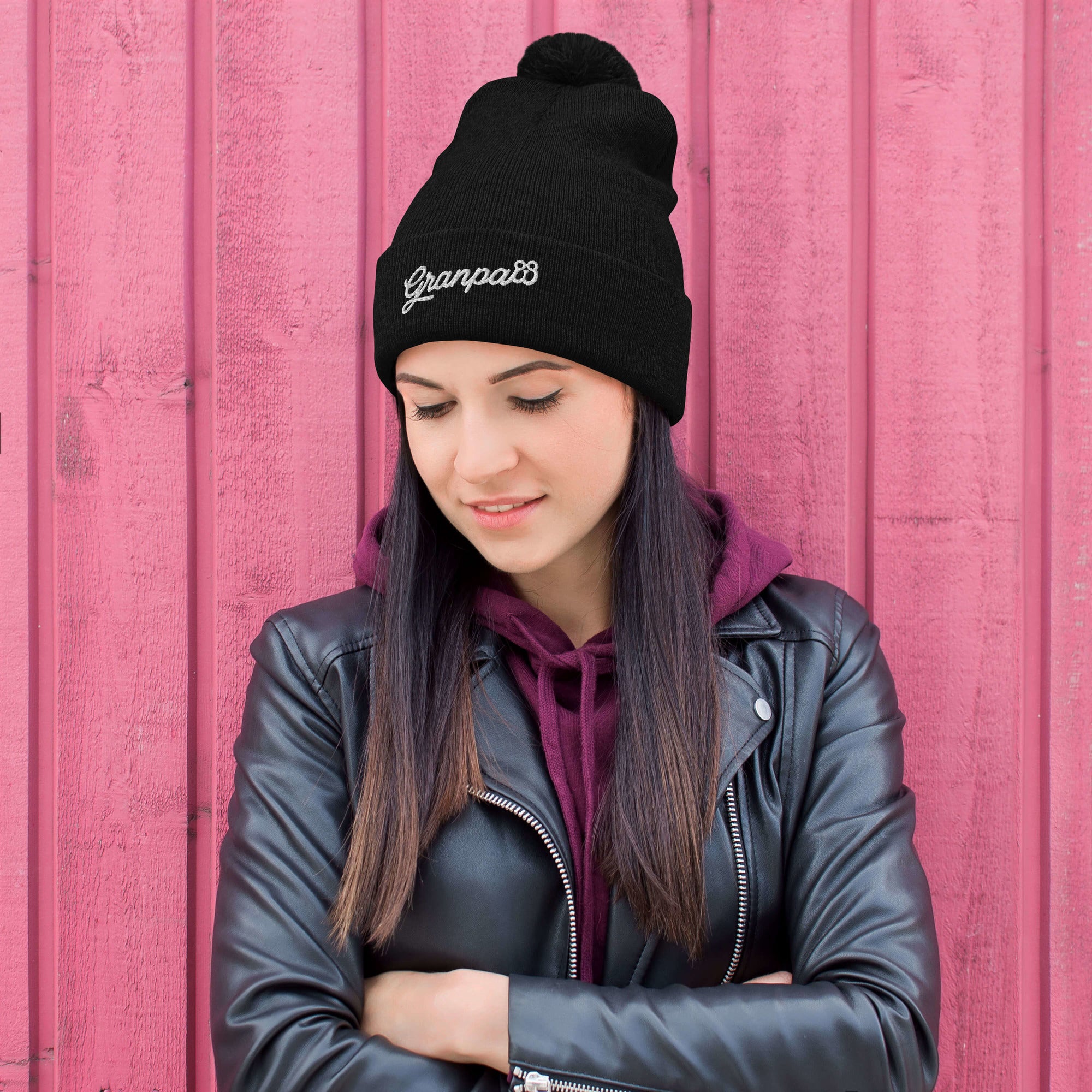 Person wearing a black beanie with 'Grampaw's' text against a pink background
