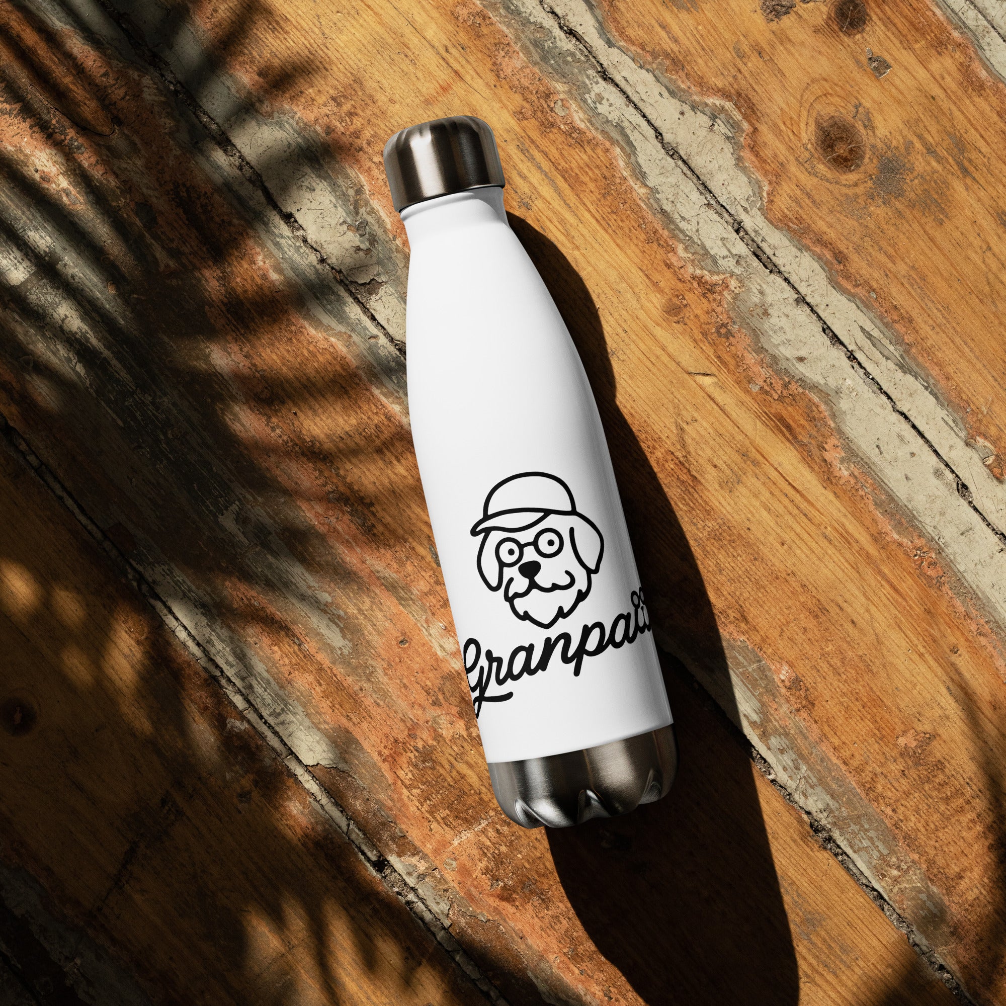 White water bottle with a dog graphic and 'Granpa' text on a wooden surface