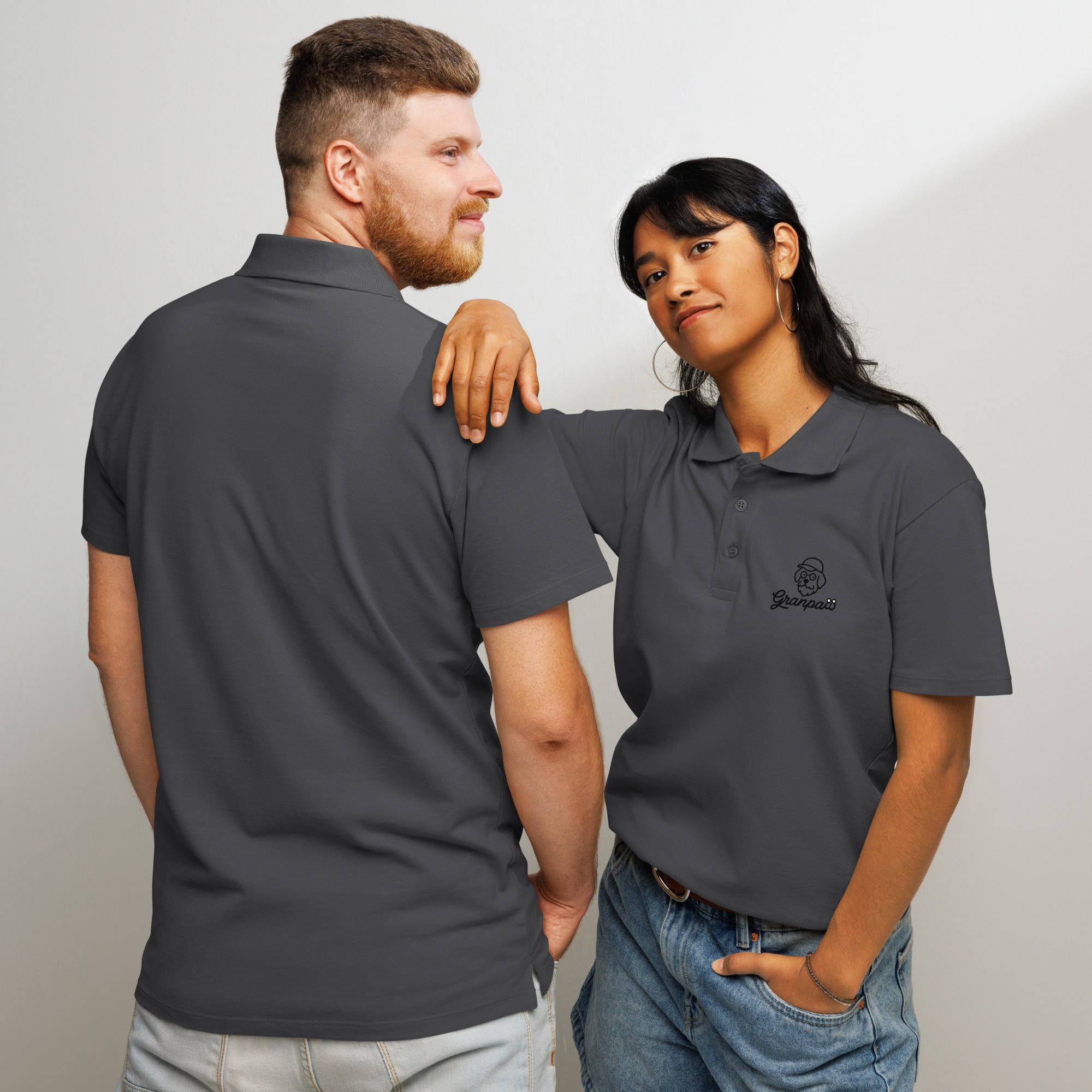Two people wearing gray polos with a logo, one facing the camera and the other back to the camera.