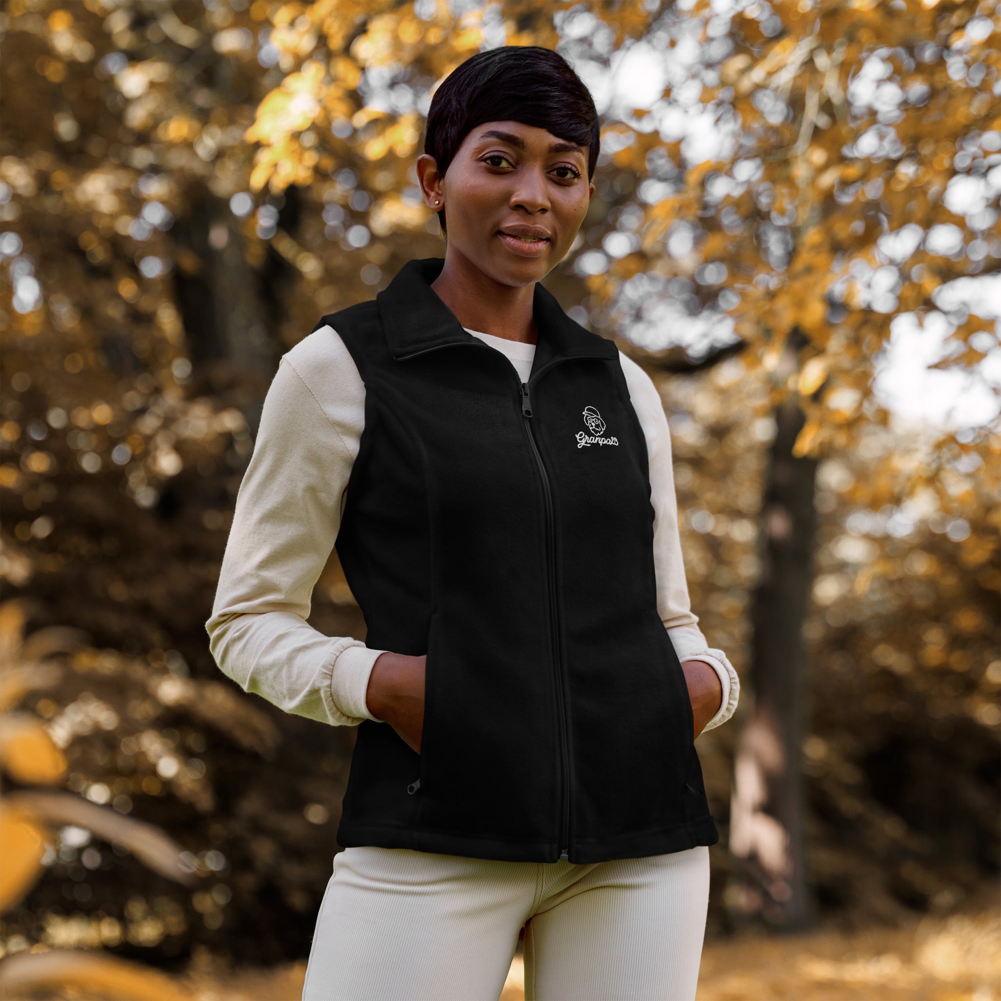 Person wearing a black vest with a logo in an autumn setting