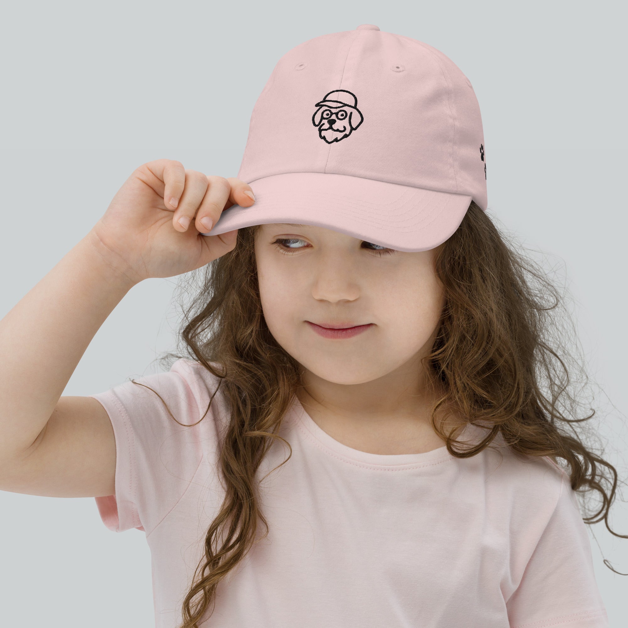 Child wearing a pink cap with a logo on a light gray background