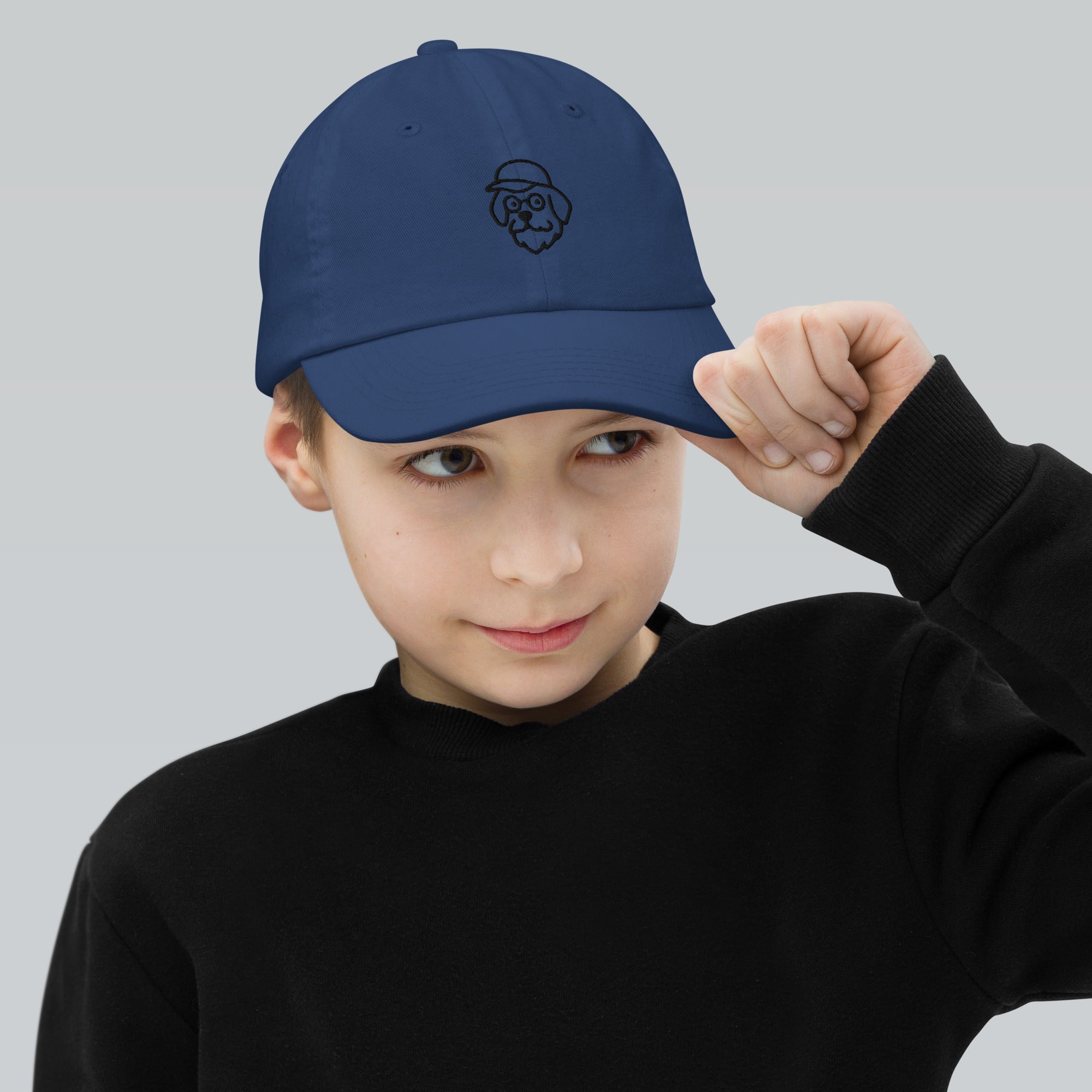 Child wearing a blue cap with a logo on a light gray background