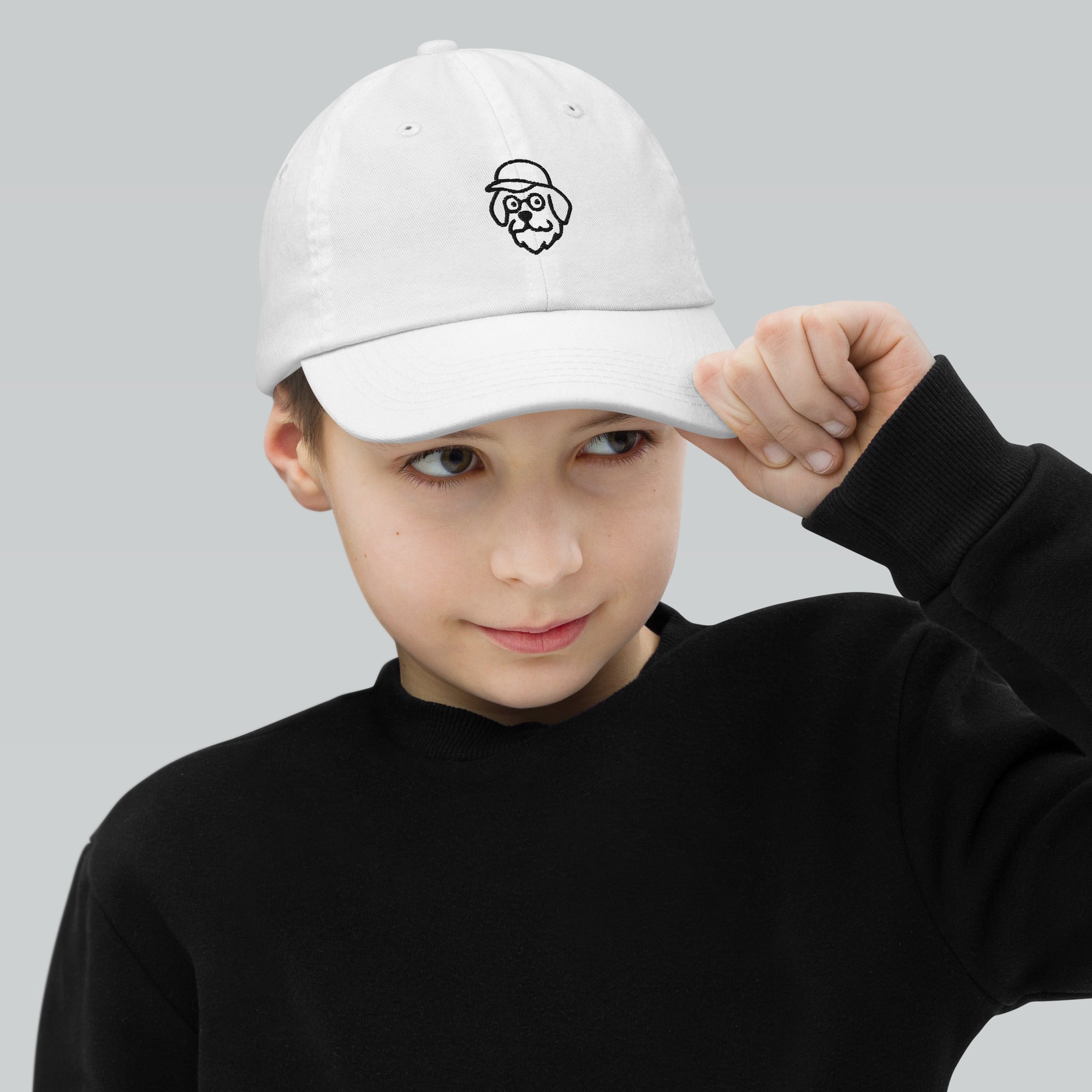 Child wearing a white cap with a logo on a gray background